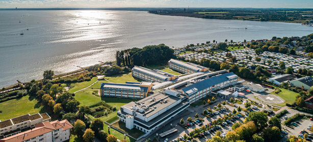 Panoramic view of the Schoen Clinic Neustadt an der Küste with clinic buildings, car parks and surrounding nature