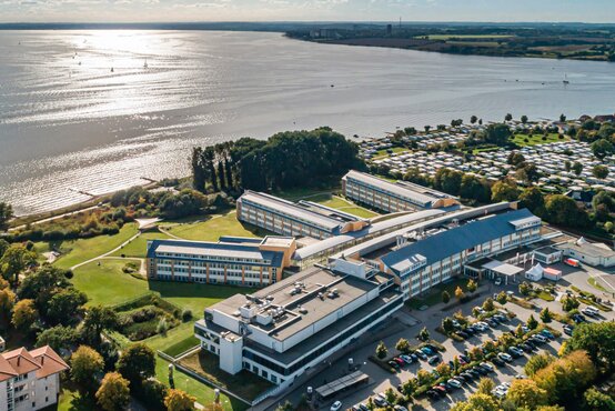 Panoramic view of the Schoen Clinic Neustadt an der Küste with clinic buildings, car parks and surrounding nature