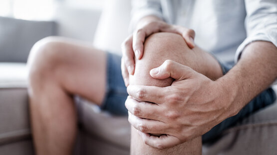 Person holding their knee with both hands